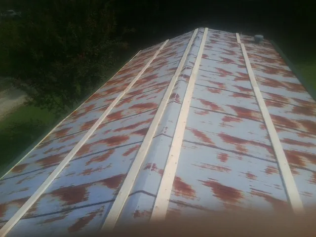 Rusted metal roof panels with new wood purlins before replacement — Storm Damage Roof Repair in Duncombe by Roofing Brothers