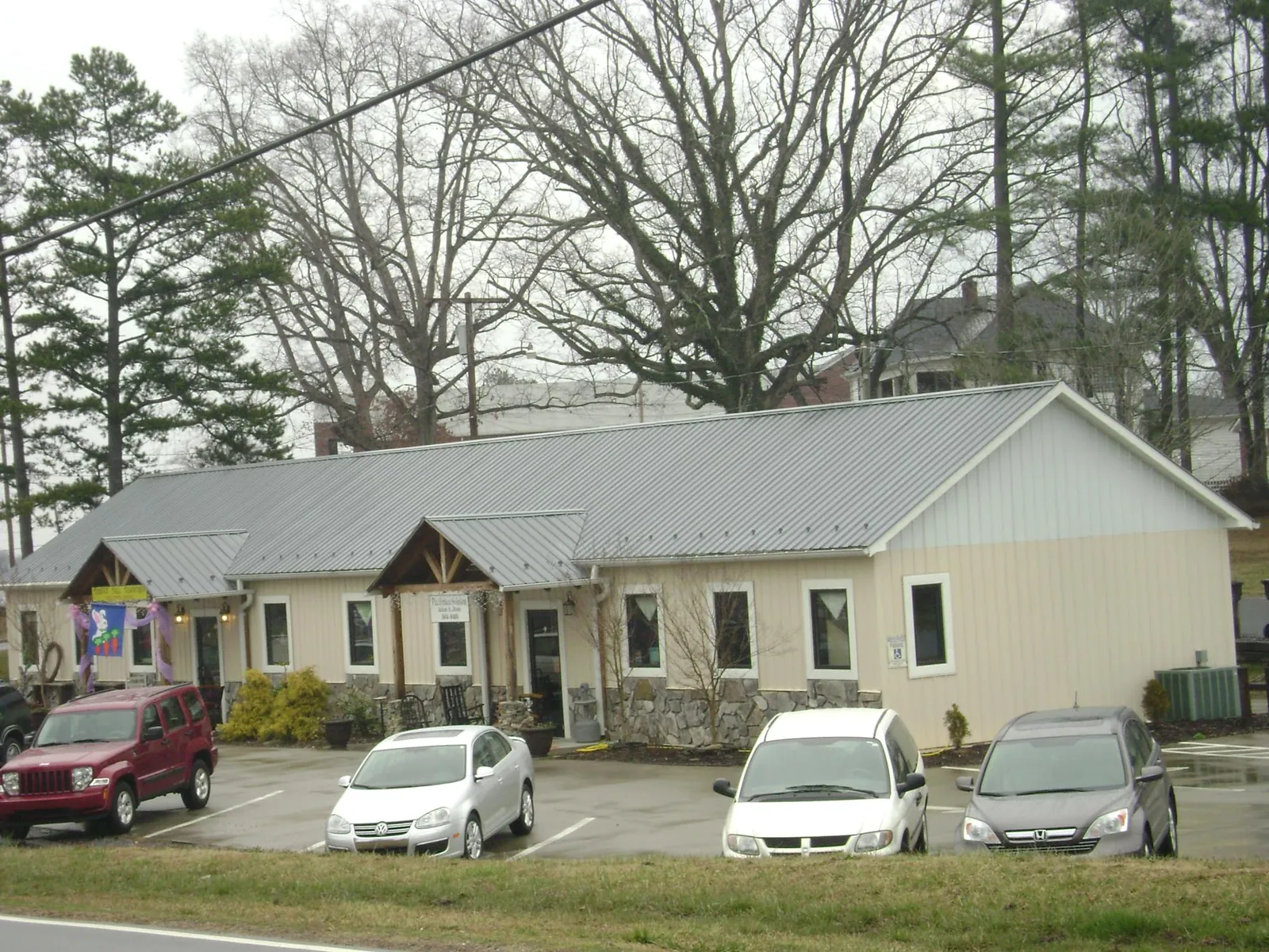 Gray metal roof with timber entry brackets on a small commercial building in Duncombe