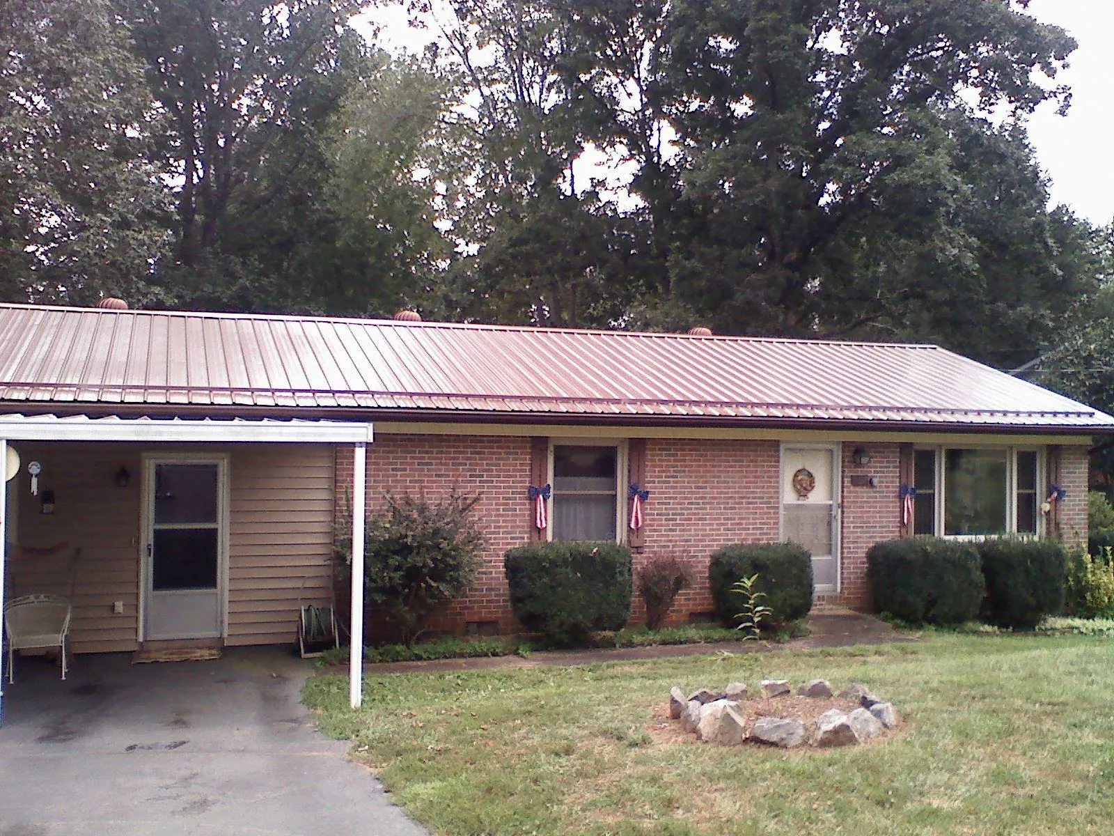 Bronze metal roof and carport on a brick ranch home — Roof Repair work by our crew in Duncombe